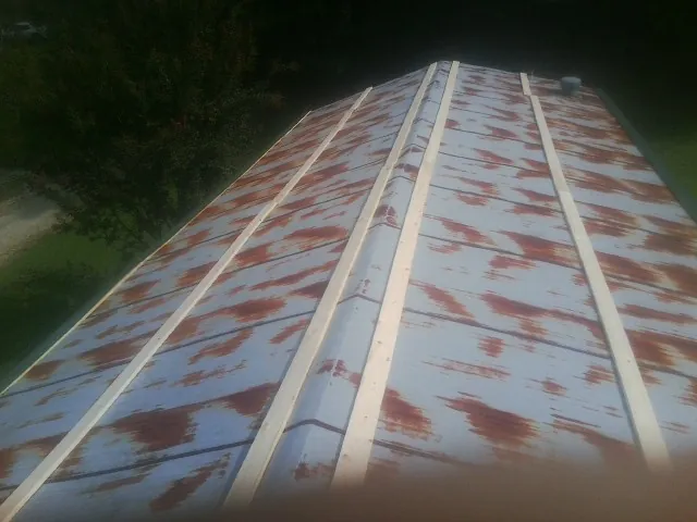 Rusted metal roof panels with new wood purlins before replacement — Storm Damage Roof Repair in Kite by Roofing Brothers